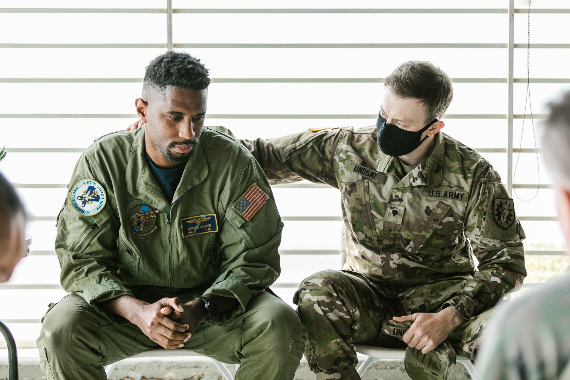 A veteran offering a supportive hand to a fellow service member